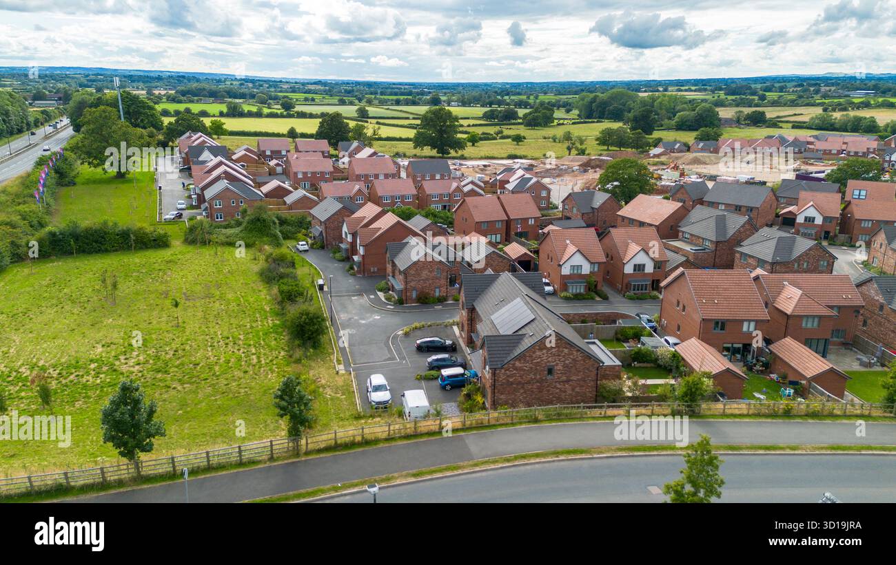 Vista aerea del villaggio di Cotchett, Mickleover, Derby, mostrando nuove case circondate da campi verdi nel South Derbyshire. Foto Stock