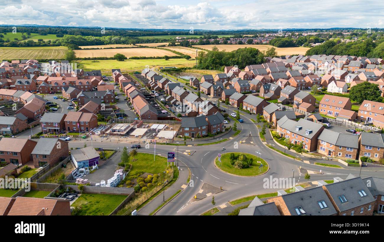 Foto aerea del villaggio di Cotchett, Mickleover, Derby, che mostra la tenuta residenziale e la rotatoria vicino alla campagna aperta. Foto Stock
