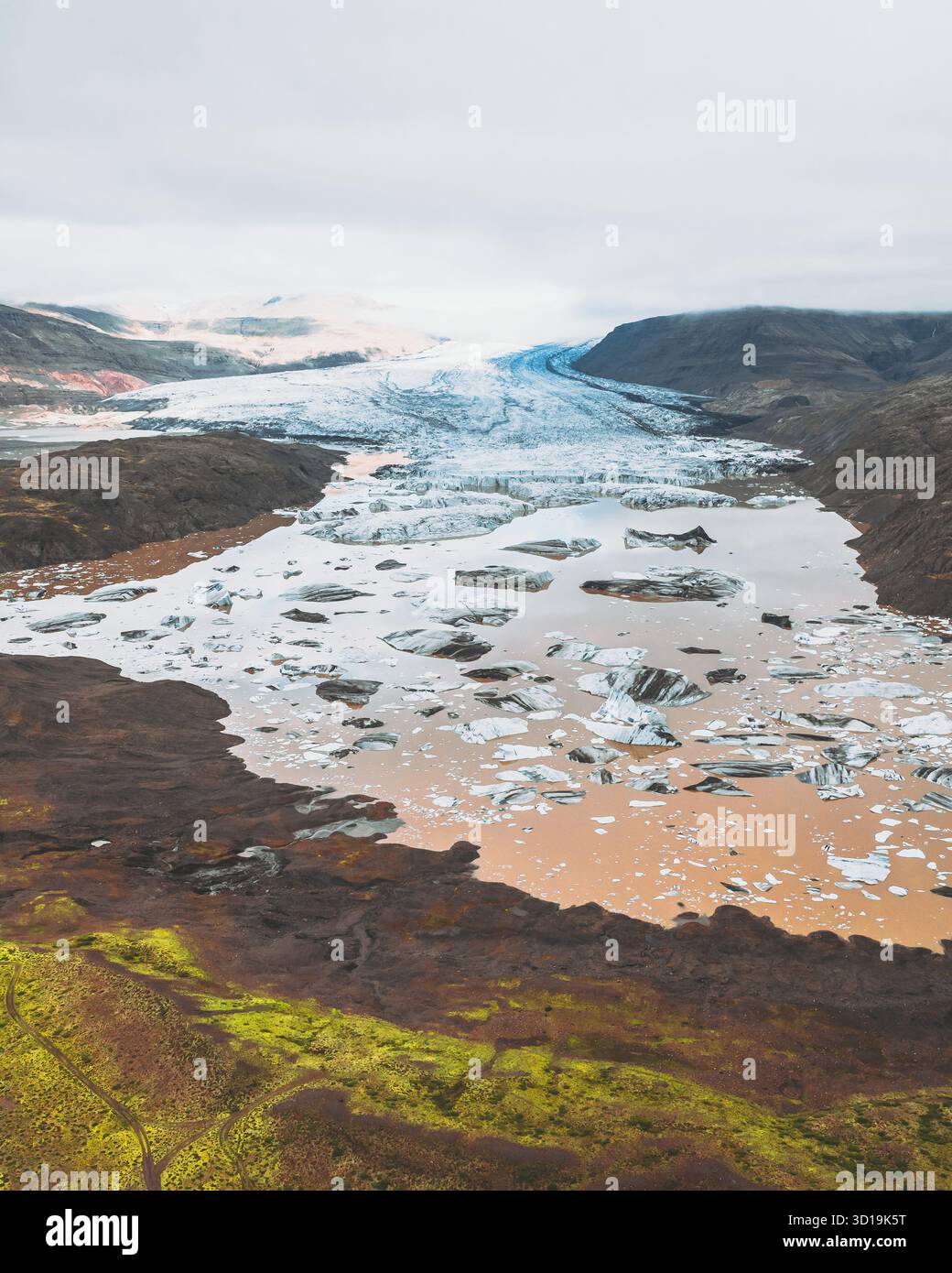 Vista aerea degli iceberg che si spostano nella laguna glaciale sullo sfondo delle aspre montagne, Heinabergsjökull, Sveitarfélagið Hornafjörður, Islanda. Foto Stock