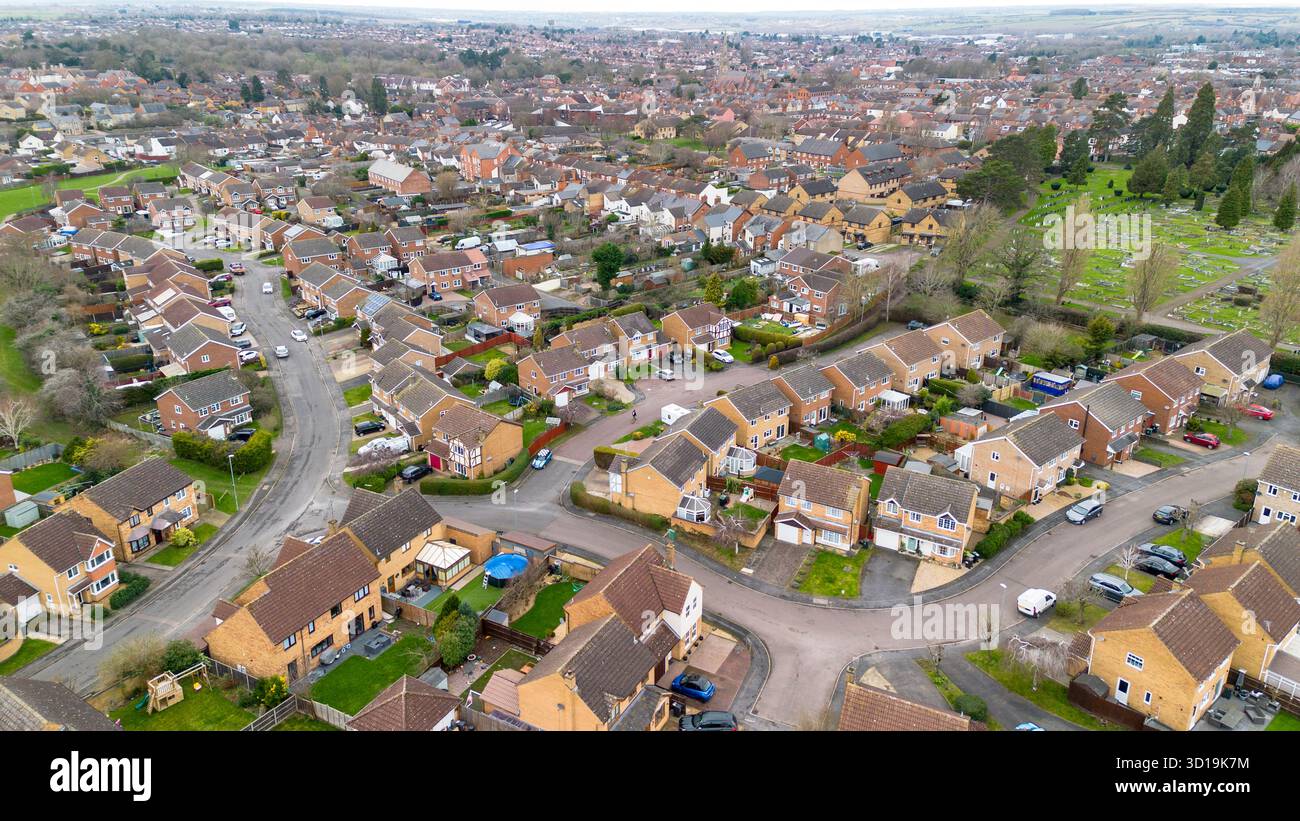 Immagine droni della periferia di Rushden, Northamptonshire, che guarda a nord attraverso le proprietà residenziali e gli spazi verdi. Foto Stock