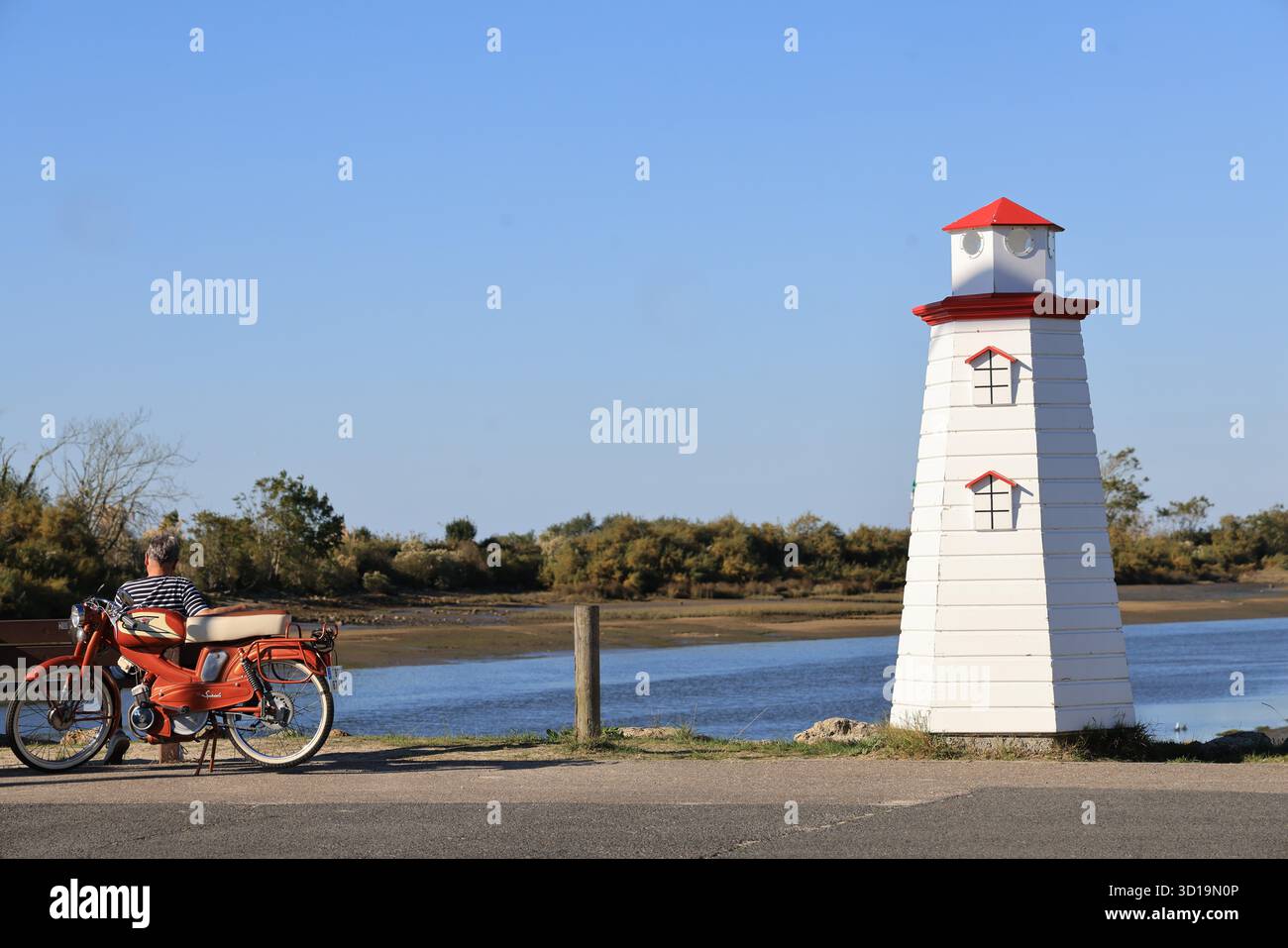 Calma e bellezza del bacino di Arcachon: Uomo con un ciclomotore d'epoca che contempla la baia di Arcachon. Francia Foto Stock