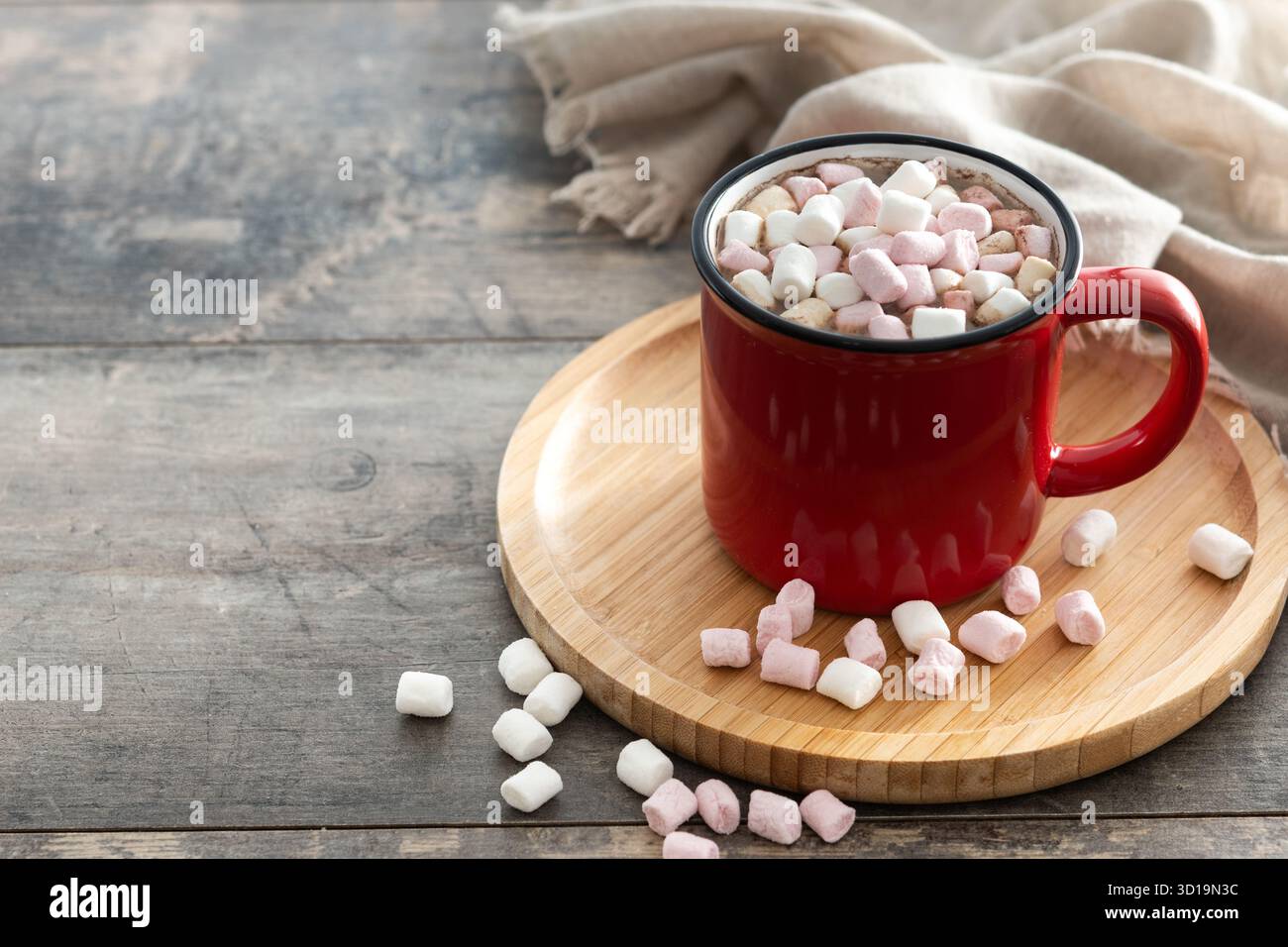 Bevanda calda a base di cioccolata con marshmallow in tazza rossa su un tavolo di legno Foto Stock