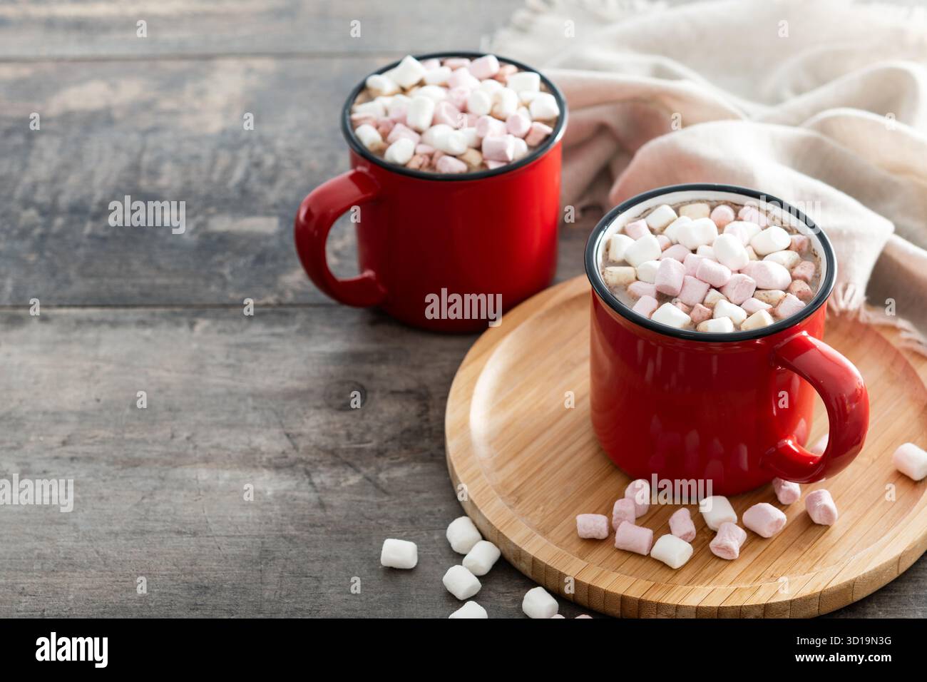 Bevanda calda a base di cioccolata con marshmallow in tazza rossa su un tavolo di legno Foto Stock