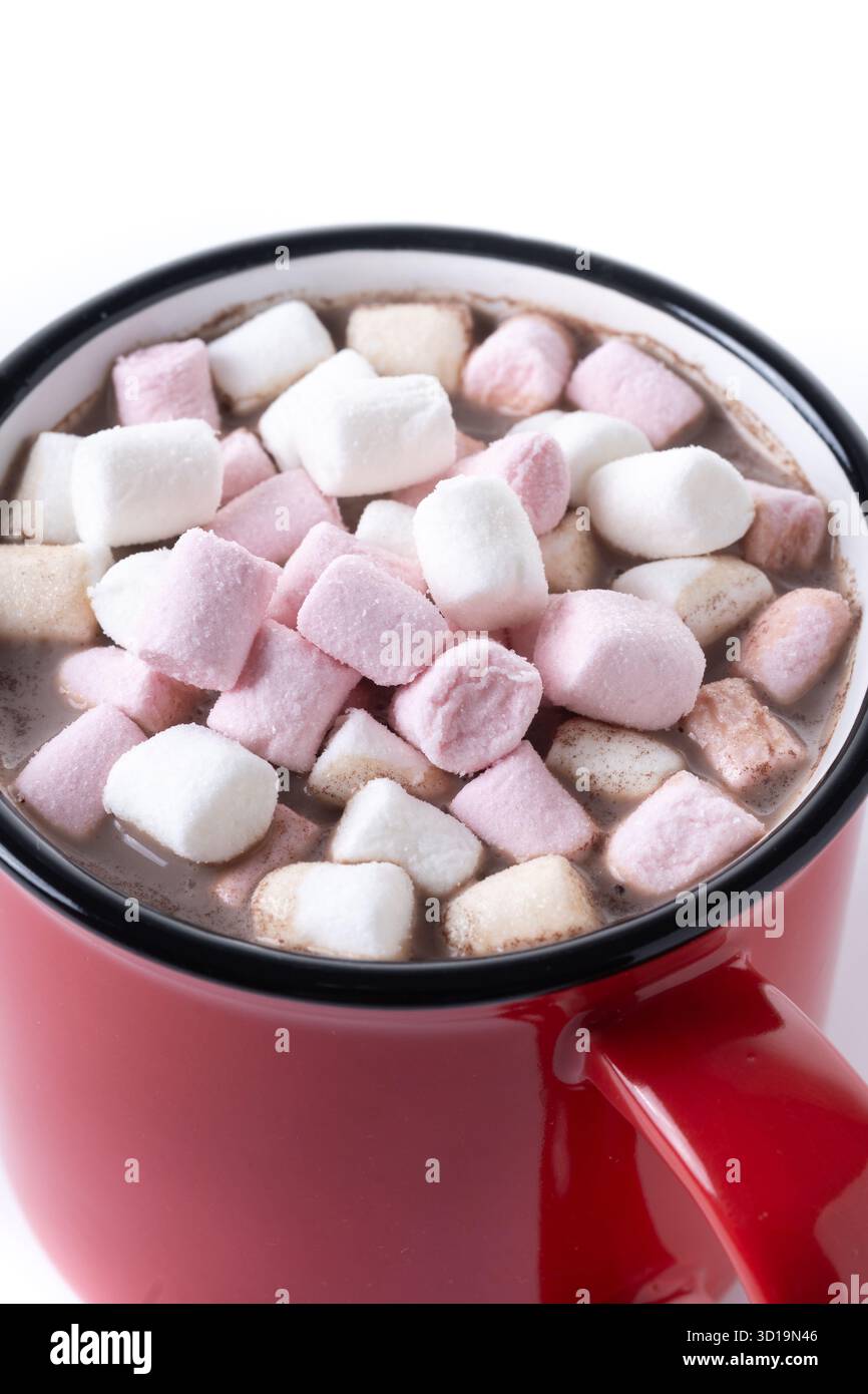 Bevanda al cioccolato caldo con marshmallow in tazza rossa isolata su una superficie bianca Foto Stock