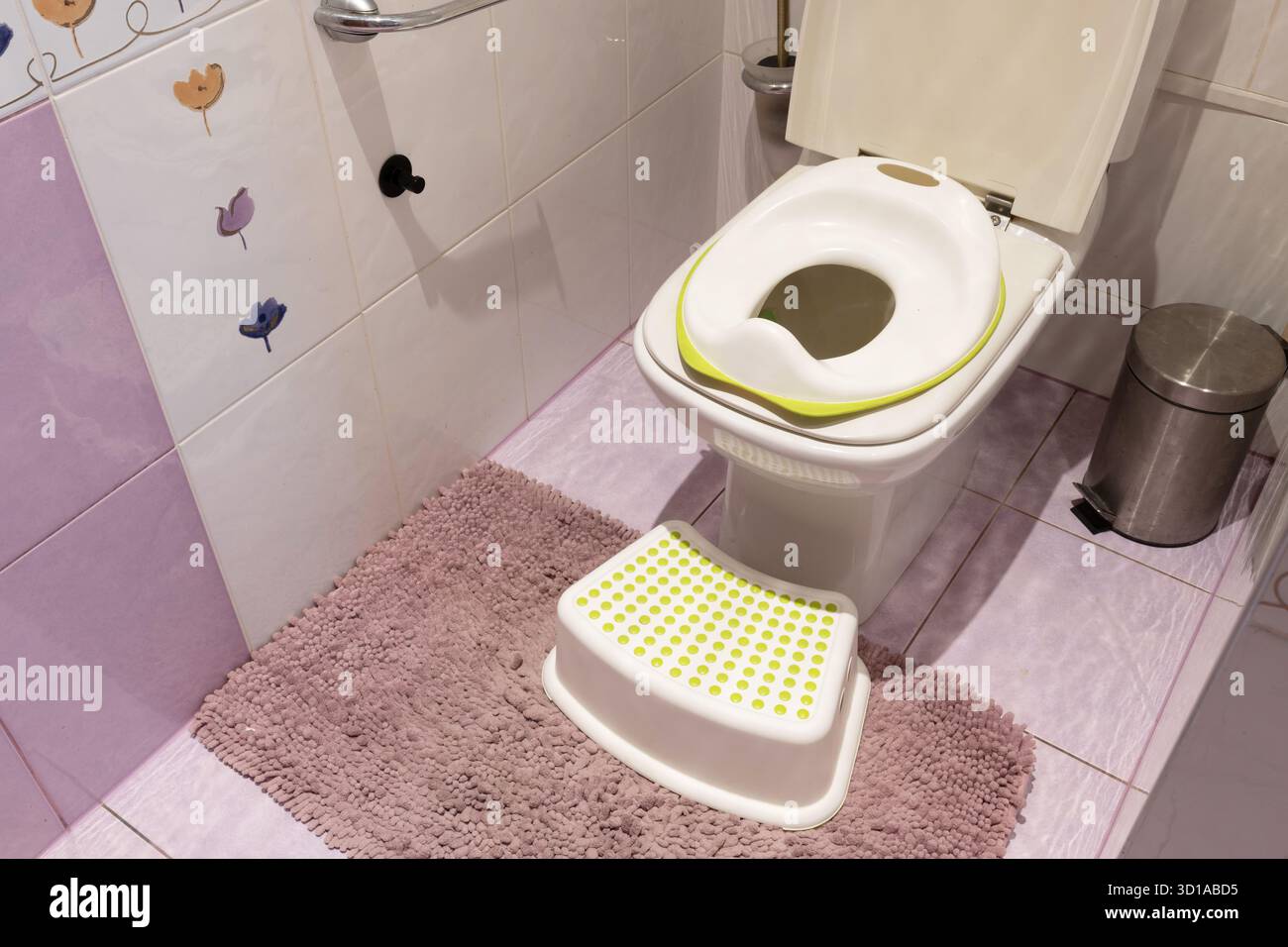 WC per bambini in cima al grande WC e gradino in plastica sul tappeto in bagno Foto Stock