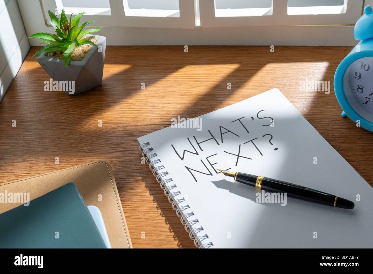 Notebook con le parole "What's Next?" scritto su una pagina. Pianificazione, decisioni future, strategia di carriera e concetto di definizione degli obiettivi. Foto Stock