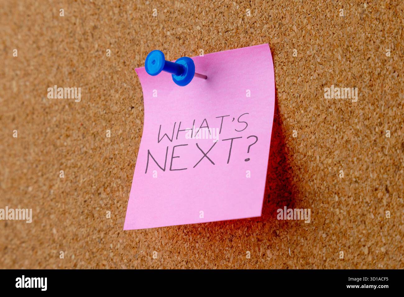 Annotare con le parole "COSA C'È DOPO?" fissato a un bordo di sughero. Pianificazione, obiettivi futuri e concetto decisionale. Foto Stock
