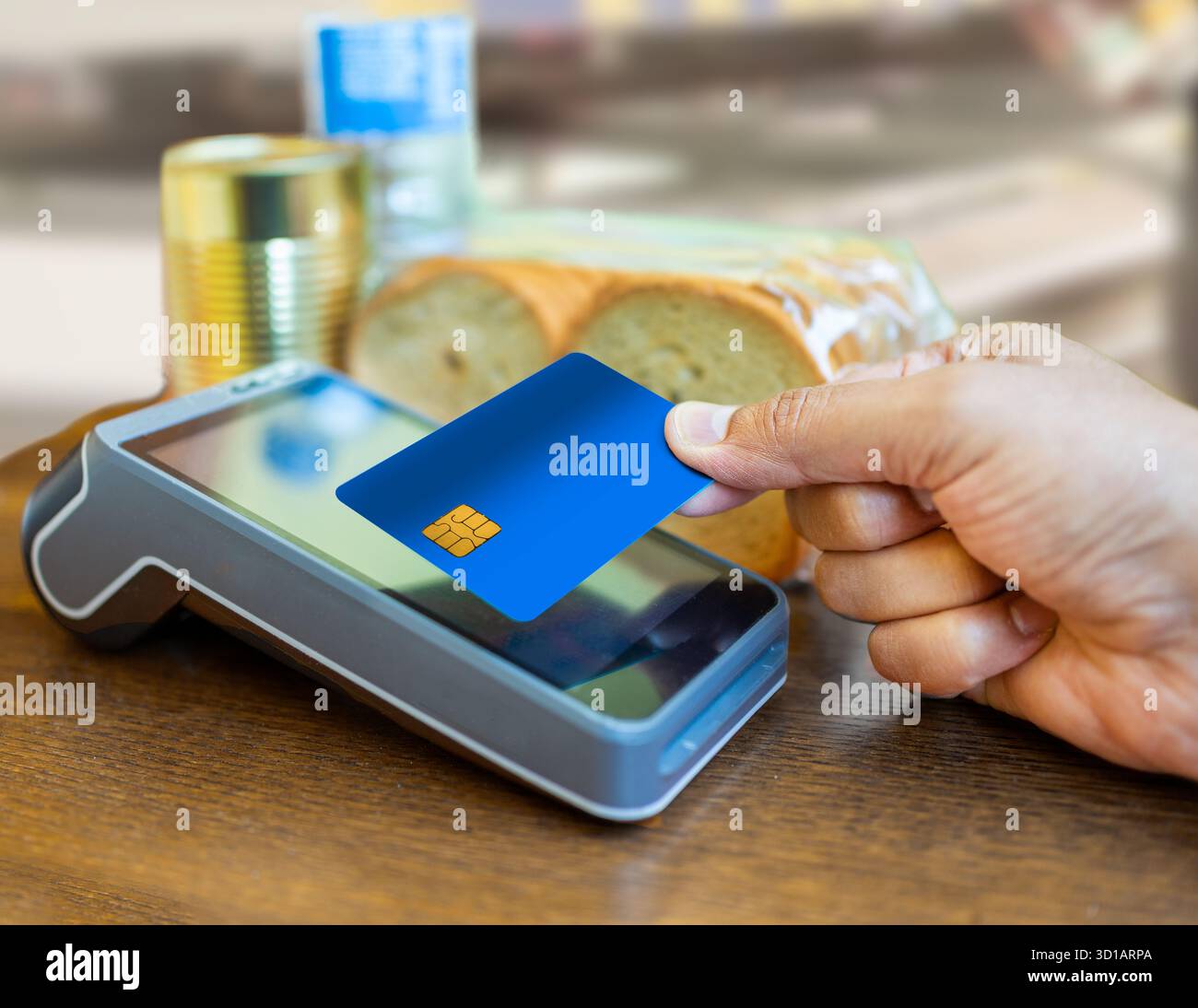 Pagamento senza contatto con carta di credito blu utilizzando la tecnologia nfc di un cliente in un supermercato o in un negozio. Mani d'uomo che toccano il lettore di macchine per carte per proce Foto Stock
