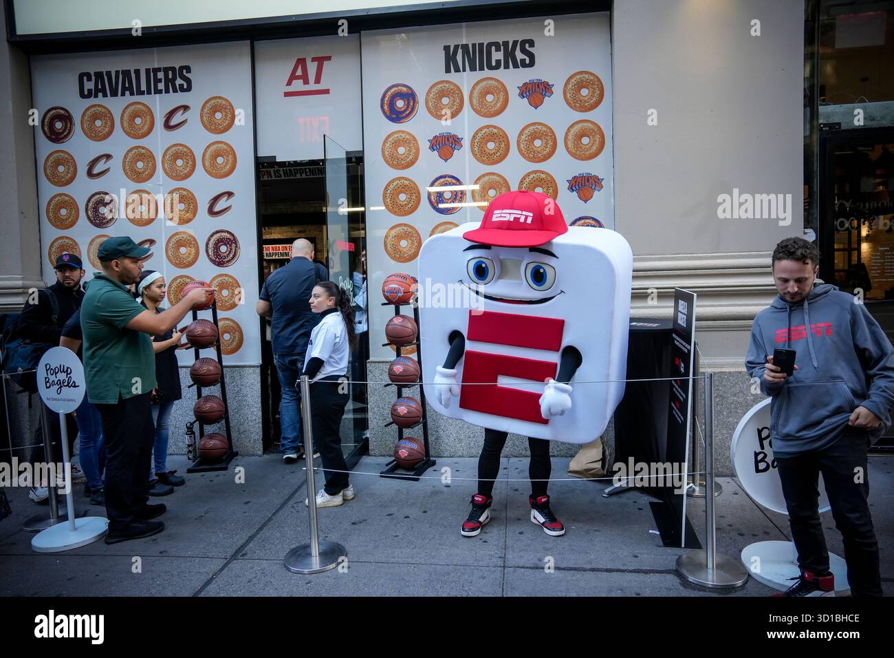 ESPN collabora con i bagel popup per l'attivazione del marchio Bagels & Buckets, promuovendo la partita di apertura dei NY Knicks e dei Cleveland Cavaliers vicino al Madison Square Garden a New York mercoledì 22 ottobre 2025. La mascotte ESPN, App-e apparve promuovendo l'app ESPN. (© Richard B. Levine) Foto Stock