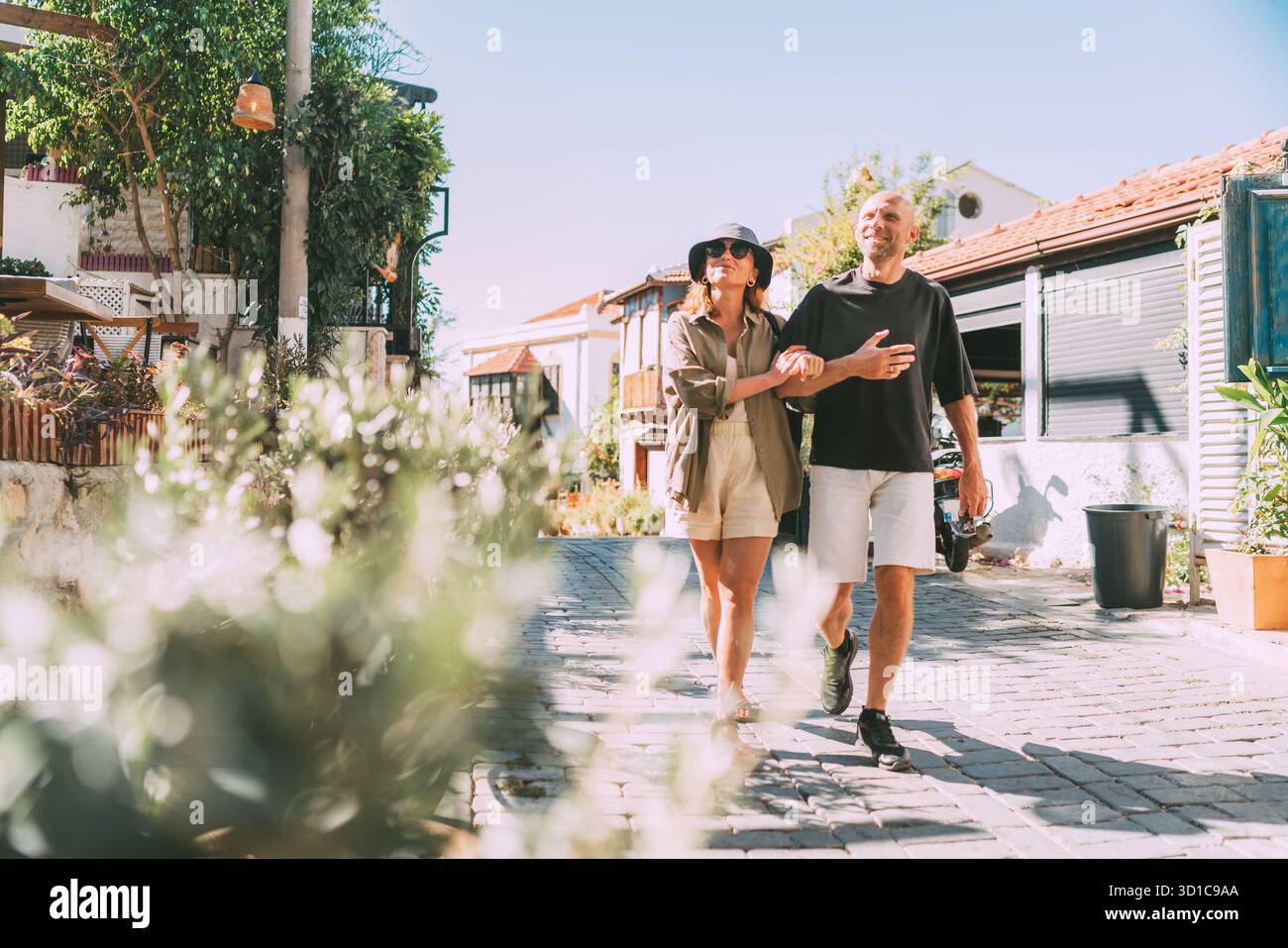 Coppia di mezza età che cammina mano nella mano lungo una stradina stretta nel centro storico della città di Kas. Viaggi romantici, relazioni d'amore, vacanze in luna di miele e.. Foto Stock