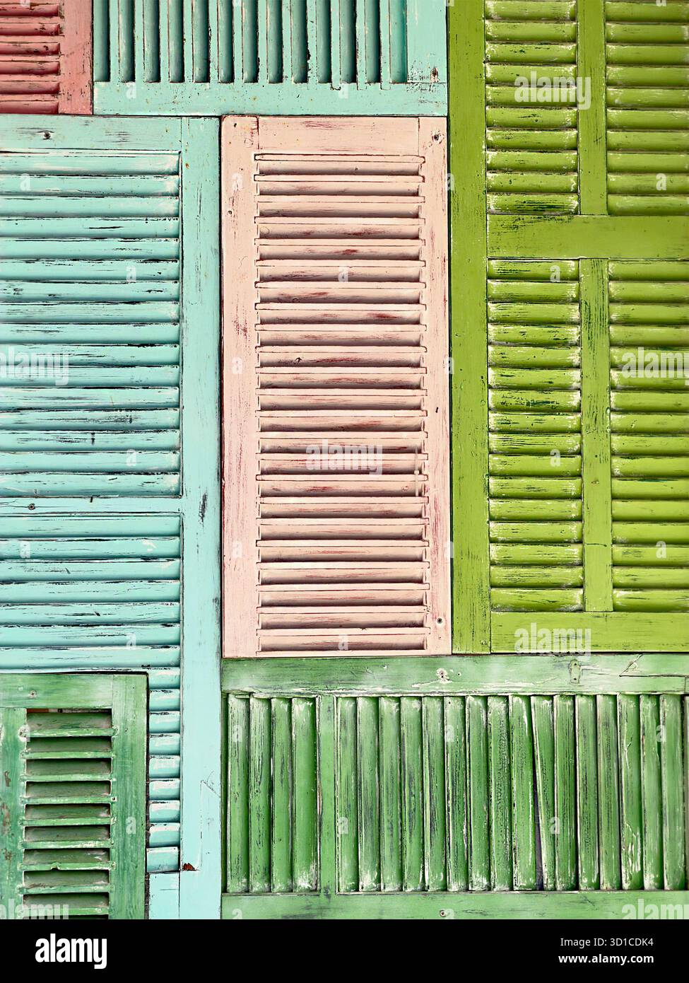Colorate pareti di patchwork realizzate con persiane in legno vintage riutilizzate nelle sfumature di verde, rosa e blu maiorca Foto Stock