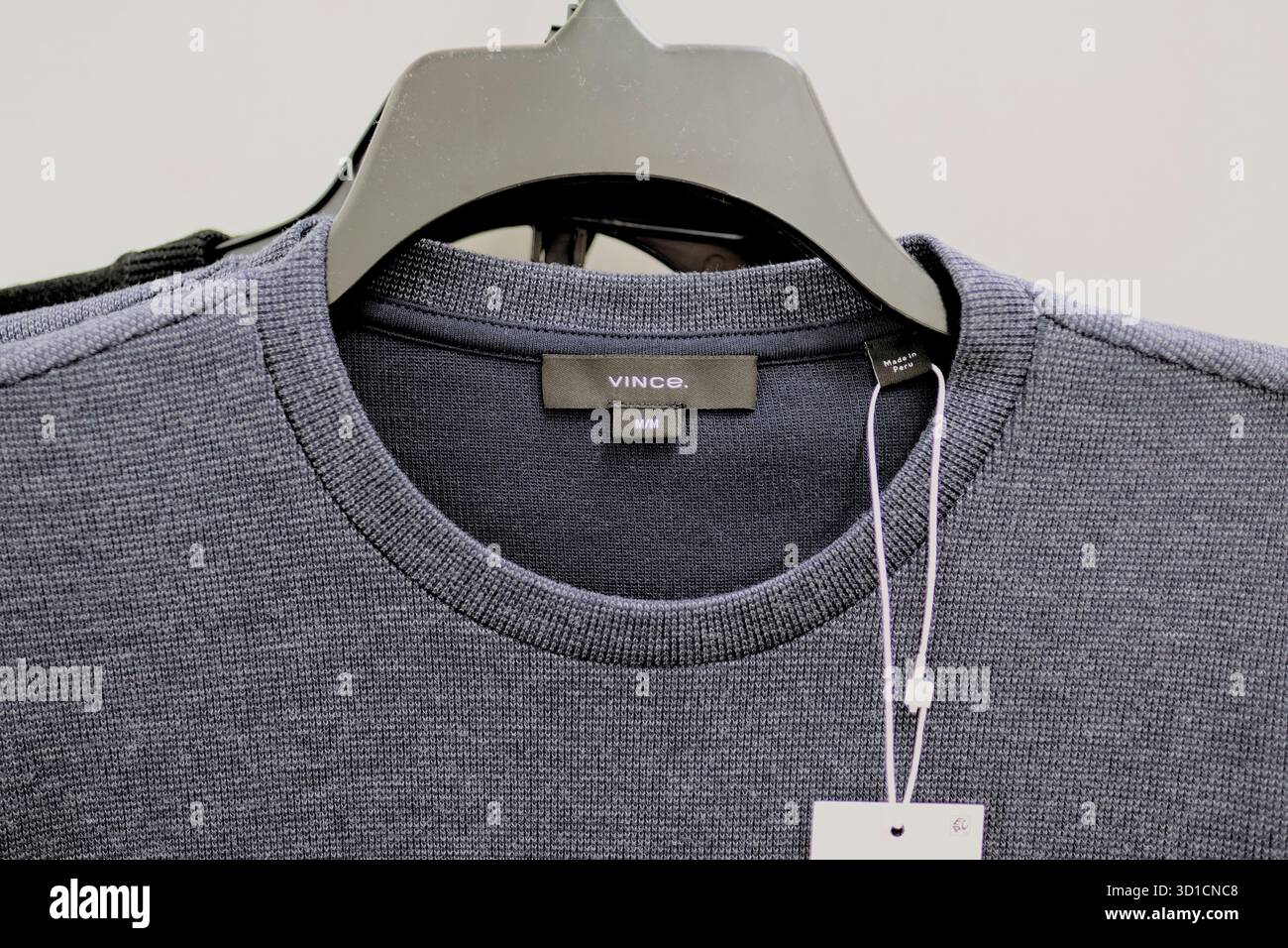 Etichetta del marchio di moda vince su un maglione grigio con un gancio; Vince. è un marchio di abbigliamento e abbigliamento contemporaneo fondato nel 2002. Foto Stock