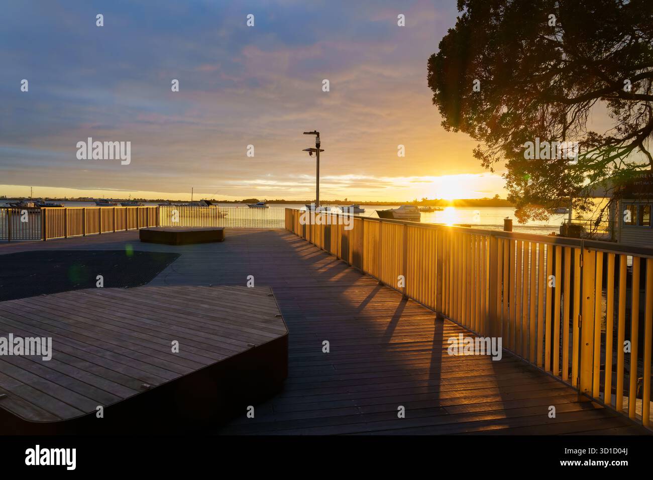 Passerella sul lungomare di Tauranga e belvedere retroilluminato dall'alba con motivi ed effetti d'ombra. Foto Stock