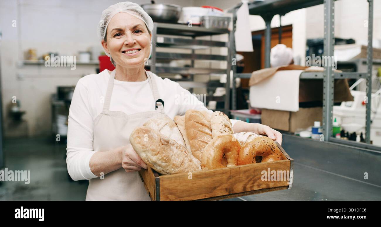 Donna, panificio e cestino del pane in ritratto con sorriso, orgoglio e imprenditore con prodotti in negozio. Persona matura, felice e proprietaria di una piccola impresa Foto Stock