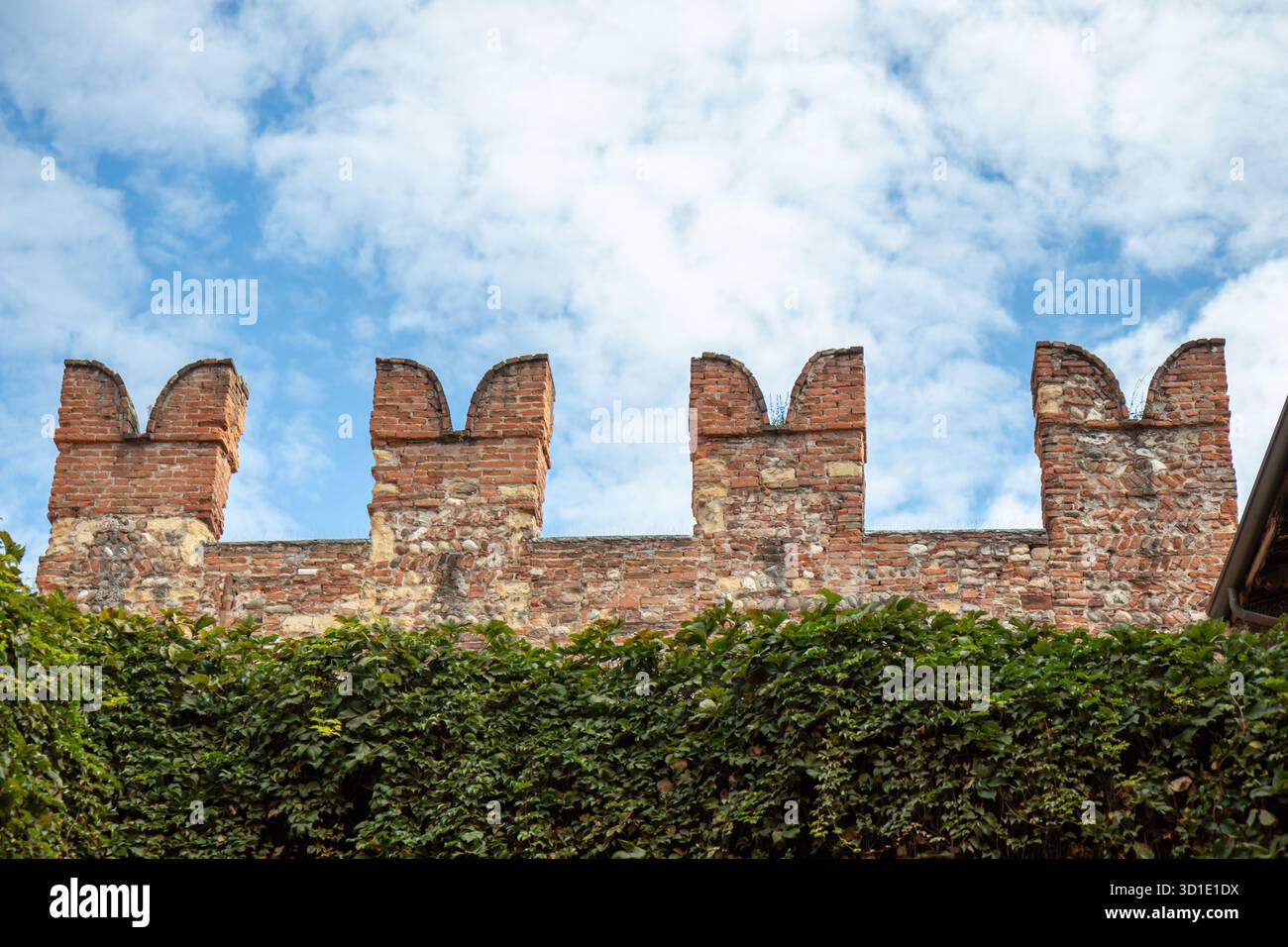 Merli o merli di coda di rondine e mattoni rossi di Castelvecchio, un castello medievale di Verona, in Italia, che mostra l'architettura fortificata e la Foto Stock