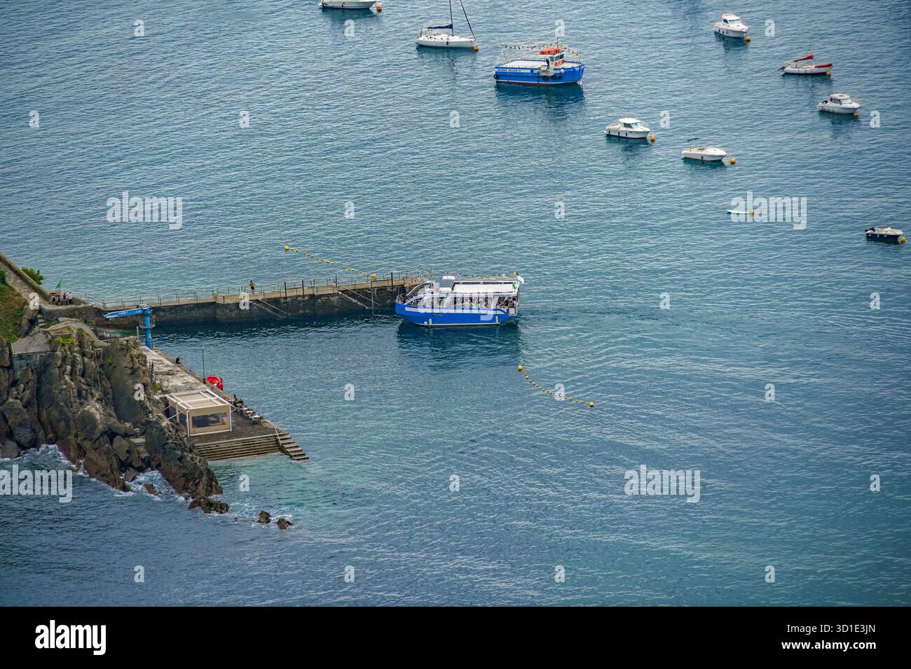 Vista ad alto angolo delle barche ormeggiate vicino al molo dell'isola di Santa Clara nella baia di la Concha, Donostia, Spagna Foto Stock
