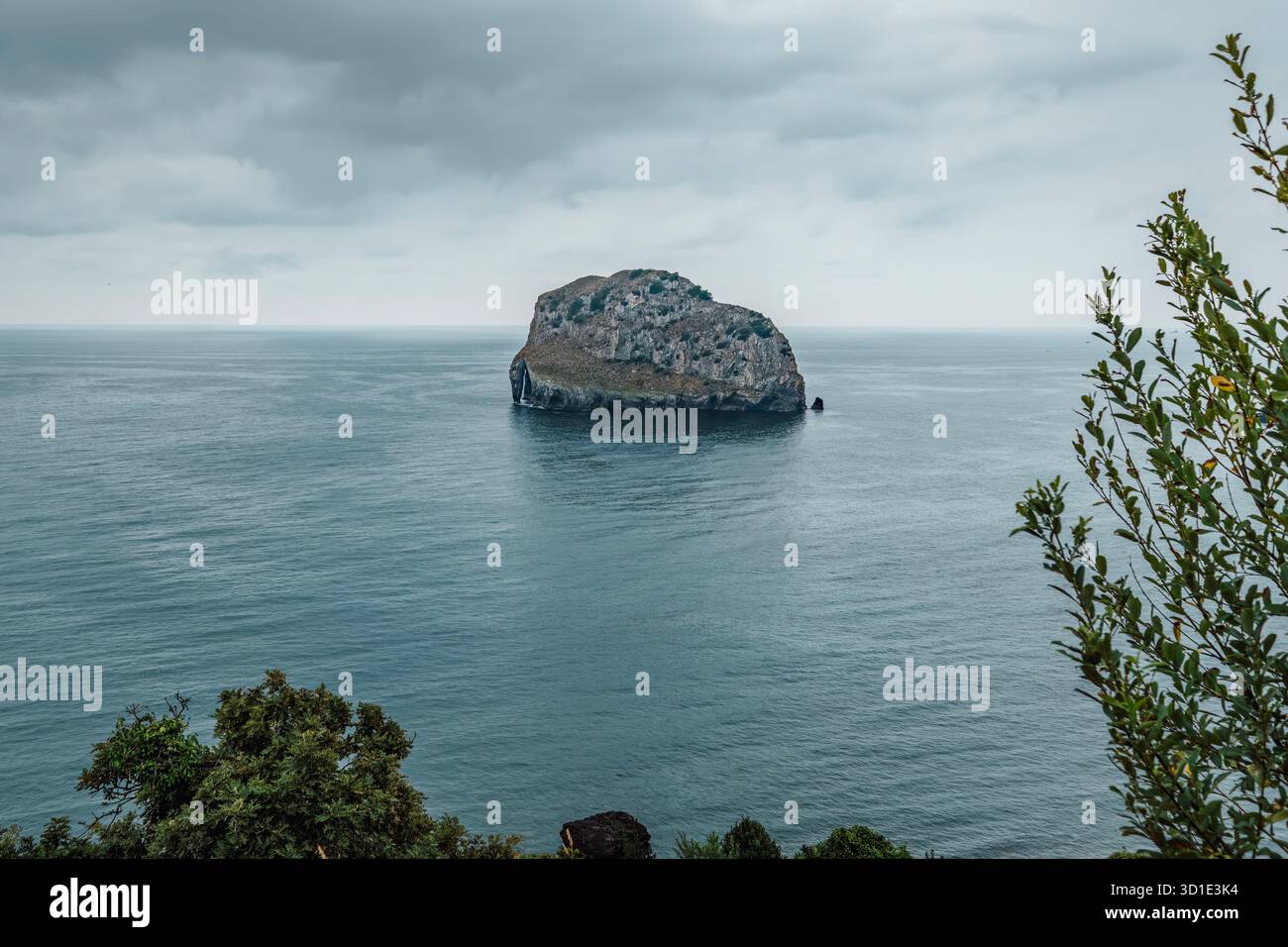 Vista spettacolare dell'isolotto roccioso di Aketx nelle acque frastagliate della Baia di Biscaglia, vicino a San Juan de Gaztelugatxe, Bermeo, Spagna Foto Stock