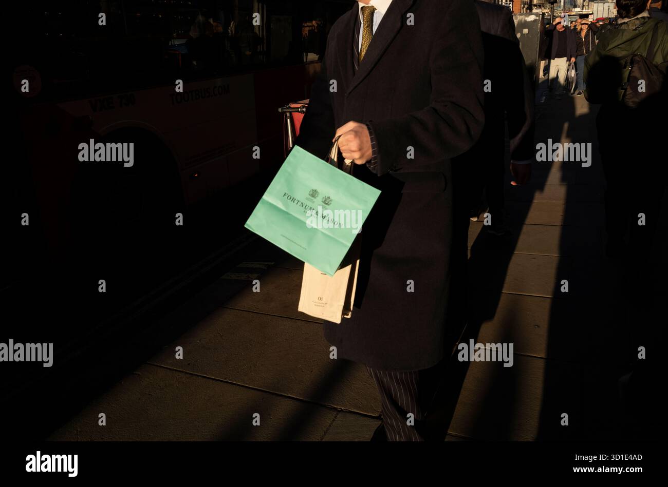 Uomo d'affari che trasporta una borsa Fortnum & Mason, Piccadilly, Londra, Inghilterra, Regno Unito Foto Stock