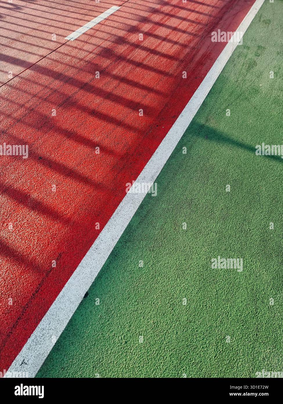Viuzze rosse e verdi - vialetto colorato e pista ciclabile. Superficie colorata con ombre lunghe. Foto Stock