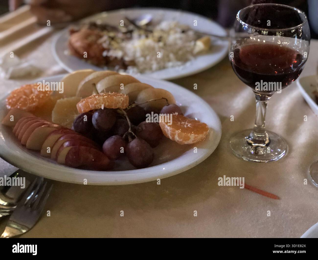 Cena servita durante una crociera sul Bosforo a Istanbul, Turchia, con frutta fresca e una bevanda sotto la luce soffusa della sera sul mare. Foto Stock