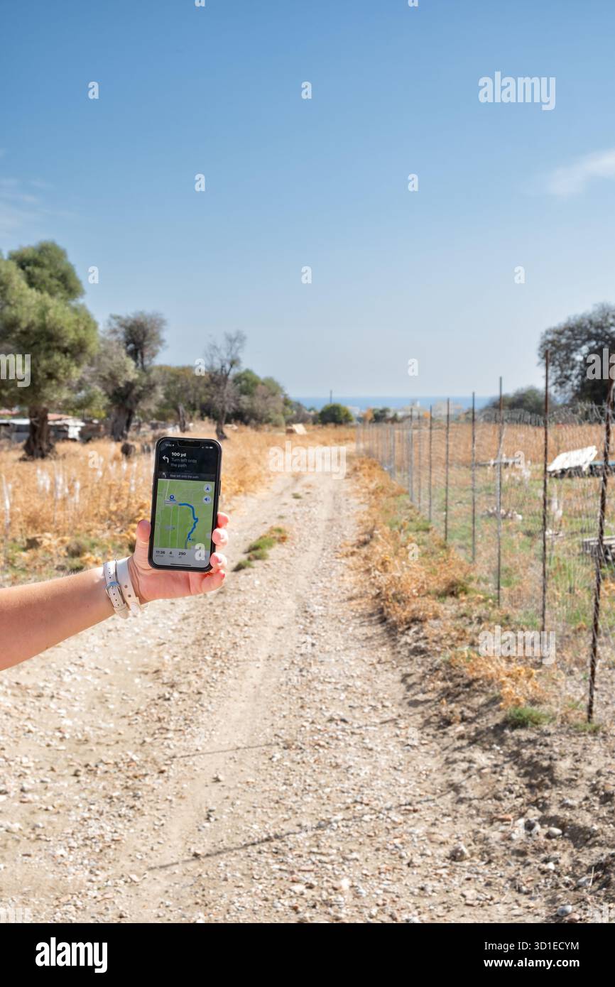 Grecia. Una donna con un iphone Apple che viene mostrato utilizzando l'app Apple Maps. L'utente sta navigando su un percorso pedonale utilizzando l'applicazione Foto Stock
