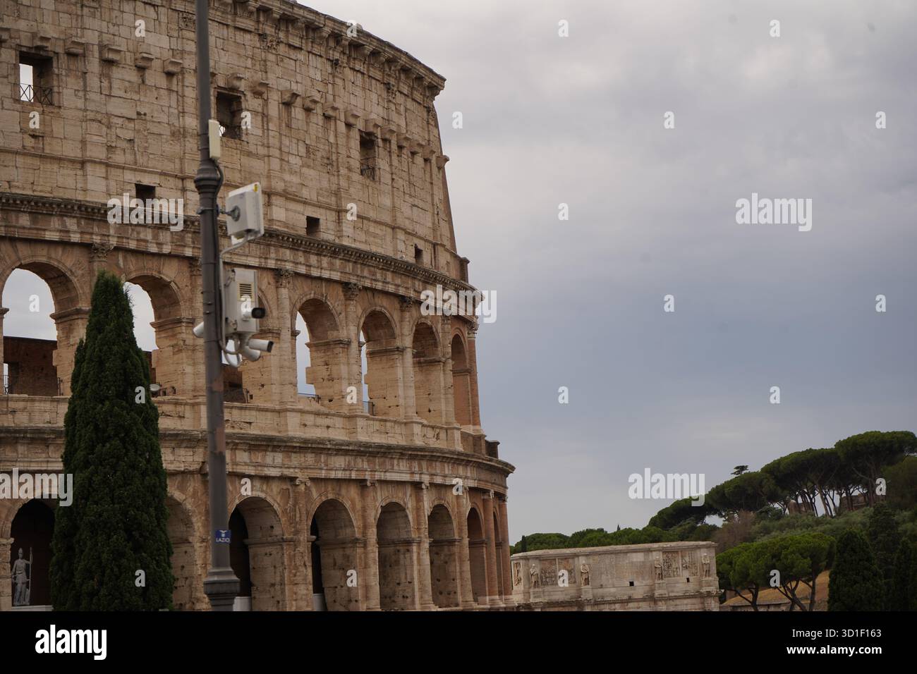 La facciata dettagliata del Colosseo contro un cielo nuvoloso. Cattura la scala storica, il decadimento e la grandezza di questo iconico monumento in tranquillità. Foto Stock