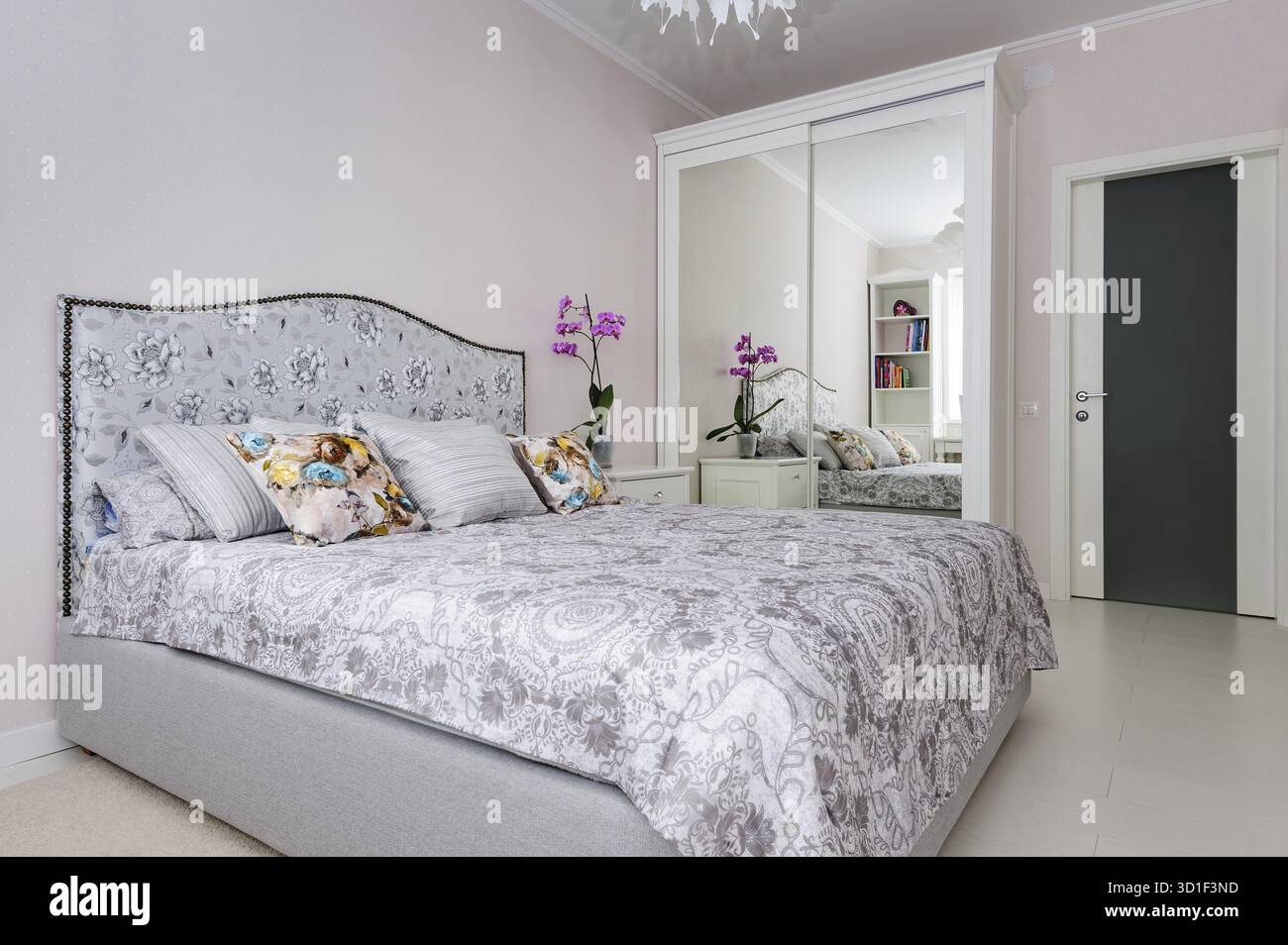 Elegante camera da letto in colori tenui e chiari, grande letto al centro Foto Stock