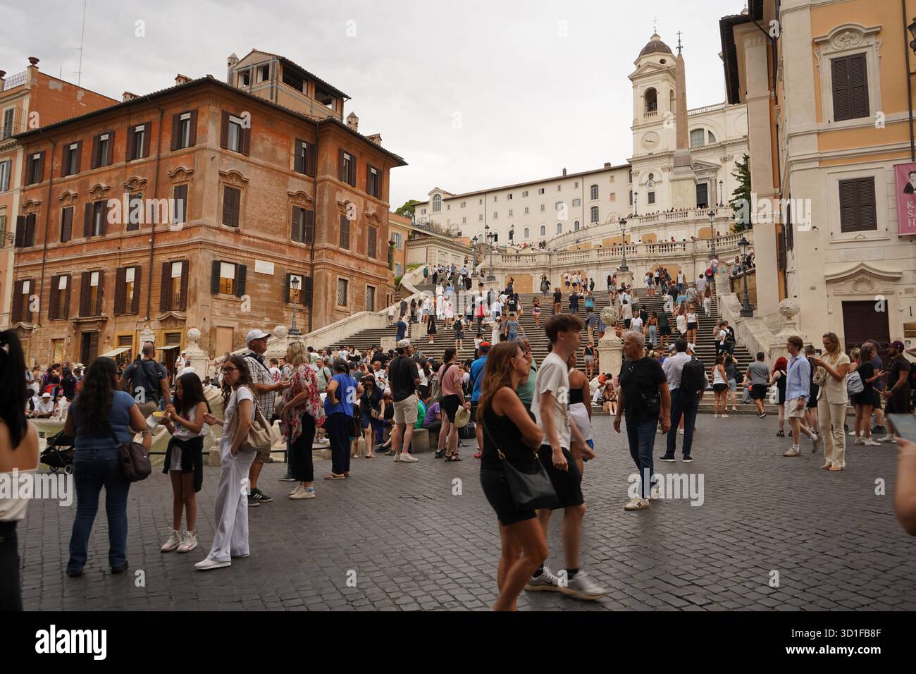 Immagine ampia della scalinata di Piazza di Spagna nella città Eterna in una giornata nuvolosa, che mostra la Scalinata di Trinità dei Monti e gli edifici storici circostanti. Foto Stock