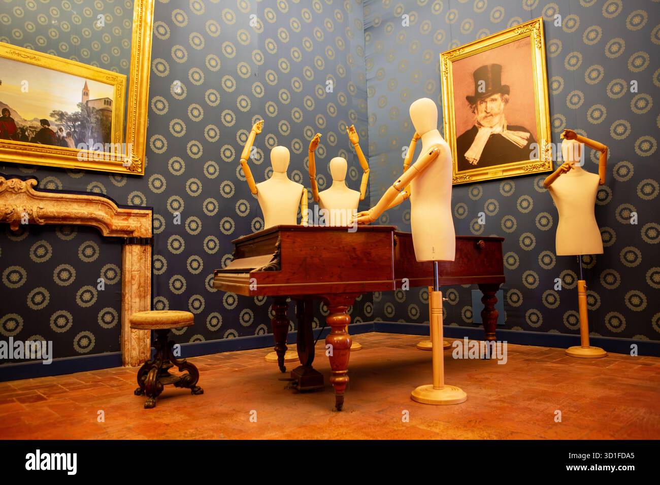 Un'installazione artistica surreale mostra manichini di legno intorno ad un pianoforte antico in una stanza in stile vintage con carta da parati a motivi geometrici. Foto Stock