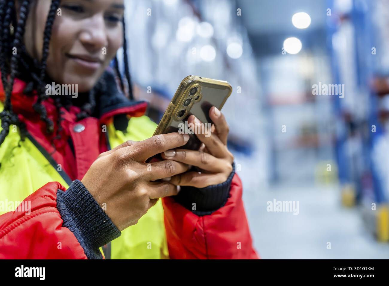 Professionisti della logistica che controllano l'inventario con un telefono cellulare, ottimizzando le operazioni della catena del freddo e gestendo la fornitura in un moderno ambiente di magazzino congelato Foto Stock