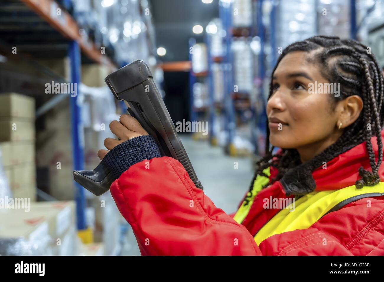 Lavoratrice donna che esegue l'inventario, esegue la scansione dei prodotti in un magazzino refrigerato, mantiene l'efficienza della catena di approvvigionamento e gestisce il magazzino frigorifero Foto Stock