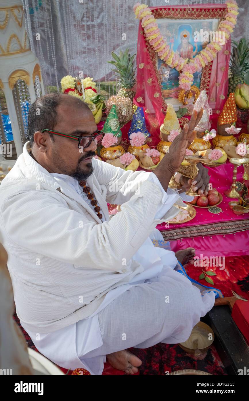 A Diwali 2025 nel Queens, un pandit indù onda una fiamma davanti all'immagine della dea Lakshmi. Nella collina South Richmand in un parco pubblico. Foto Stock