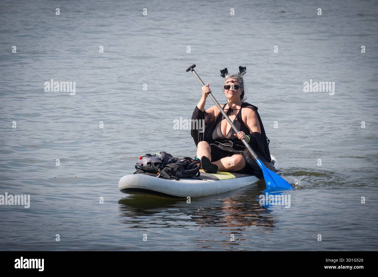 Una donna anziana pagaia sul fiume Hudson durante il 2025 UP Witches of Sleepy Hollow Festival Foto Stock