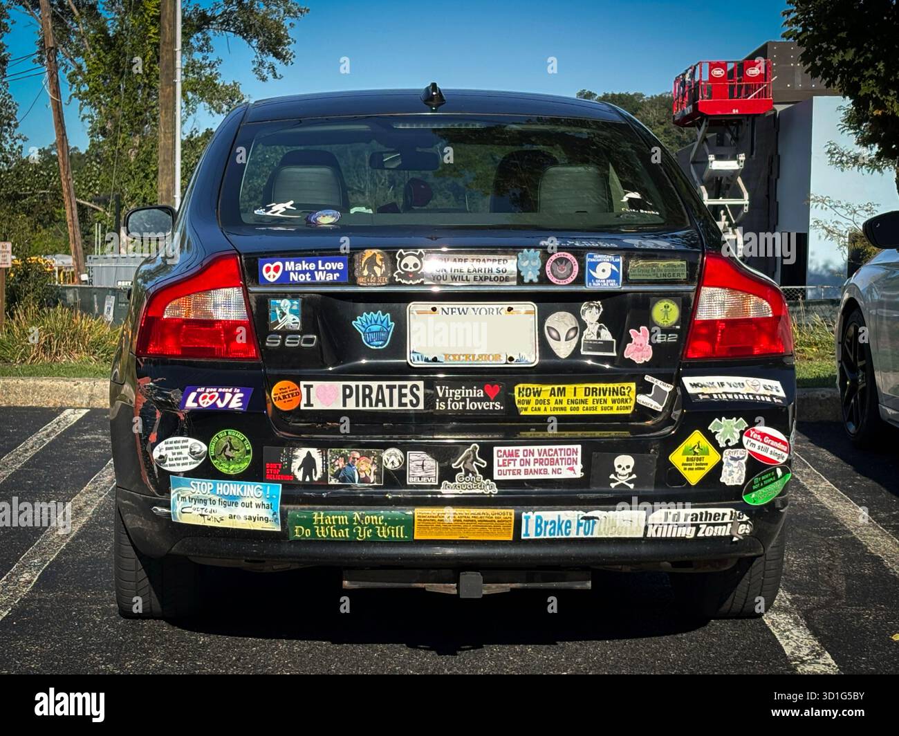 Un'auto Volvo parcheggiata con 42 adesivi per paraurti parcheggiata in molti posti a Westchester, New York. LA PIASTRA SI È SFOCATA INTENZIONALMENTE. Foto Stock