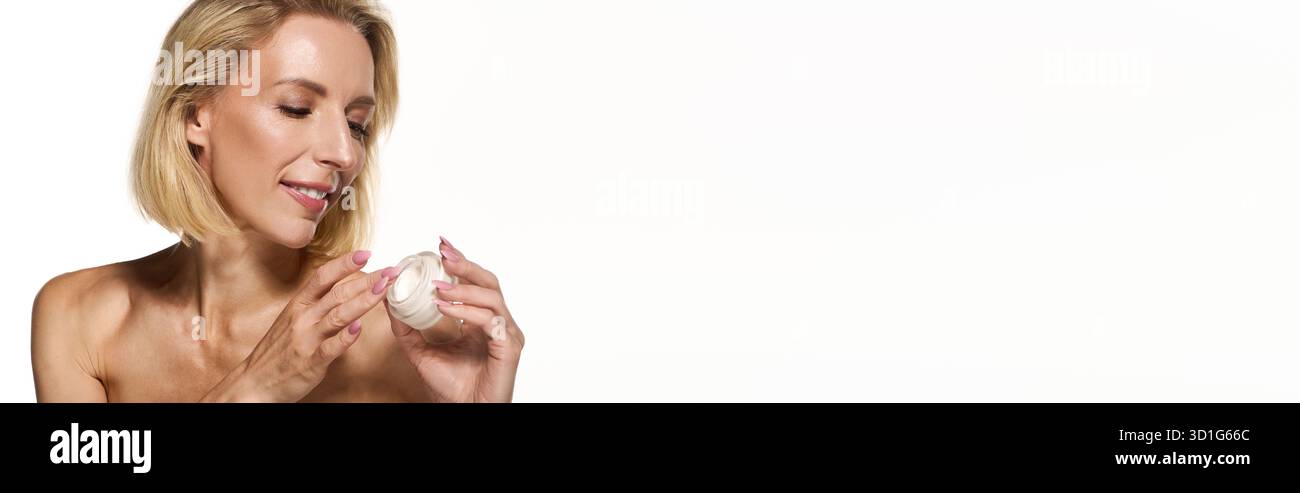Una bella donna bionda ama la sua routine di cura della pelle, evidenziando la pelle sana e radiosa, striscione Foto Stock