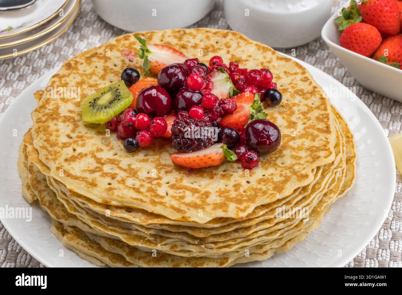Crepes con kiwi, fragole e frutti di bosco, su un tavolo Foto Stock