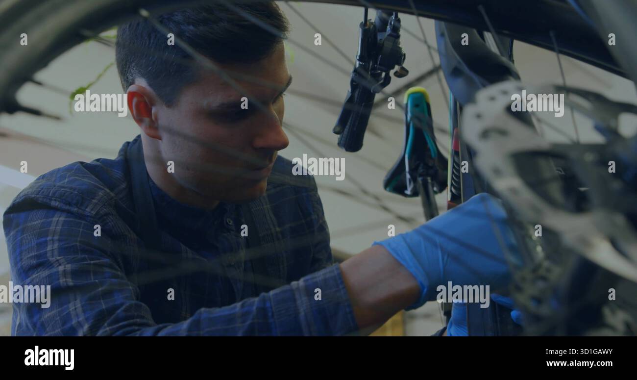 Meccanico che indossa camicia e guanti che fissa bicicletta freno a disco ruota anteriore rotore officina, spazio di copia Foto Stock