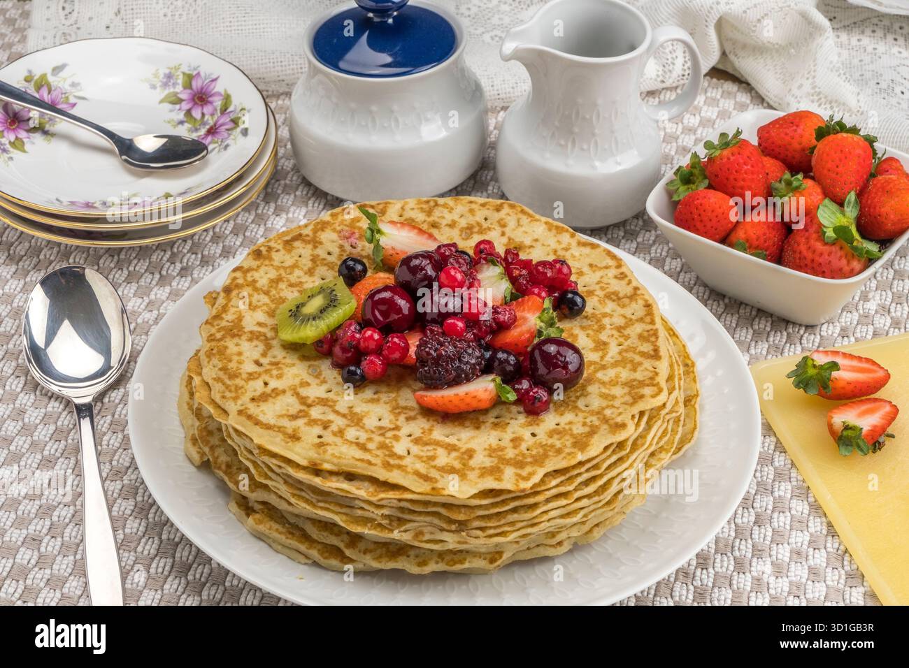 Colazione con crepes servita con kiwi, fragole e frutti di bosco Foto Stock