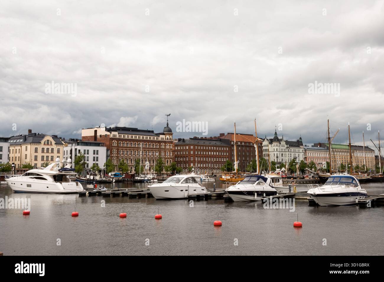 Helsinki, Finlandia - 21 giugno 2015 - Vista del porto con barche ed edifici storici in condizioni meteorologiche difficili. Foto Stock
