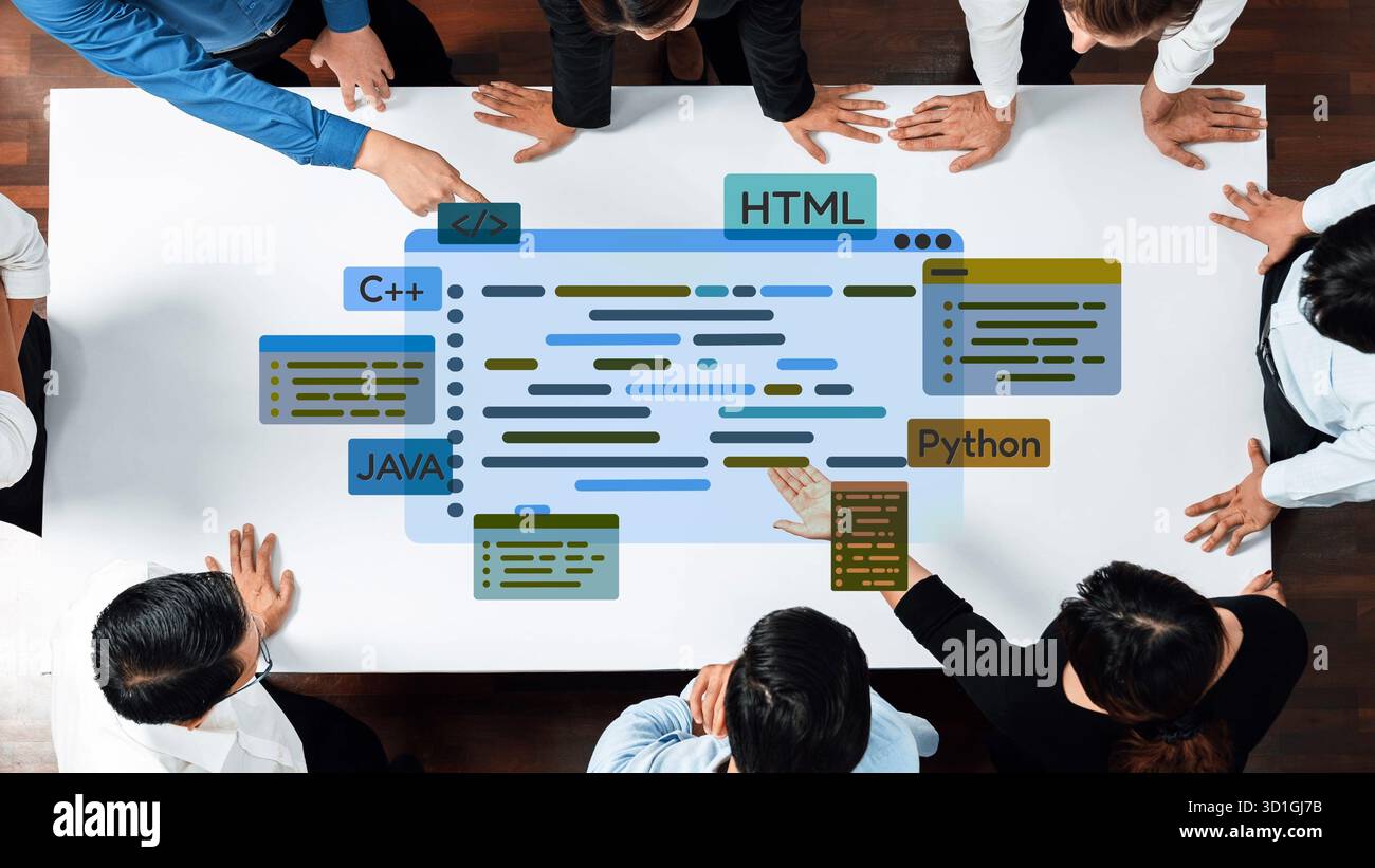 Diversi professionisti collaborano sui concetti di programmazione rappresentati visivamente su un tavolo, sottolineando il lavoro di squadra, la creatività e l'innovazione in Foto Stock