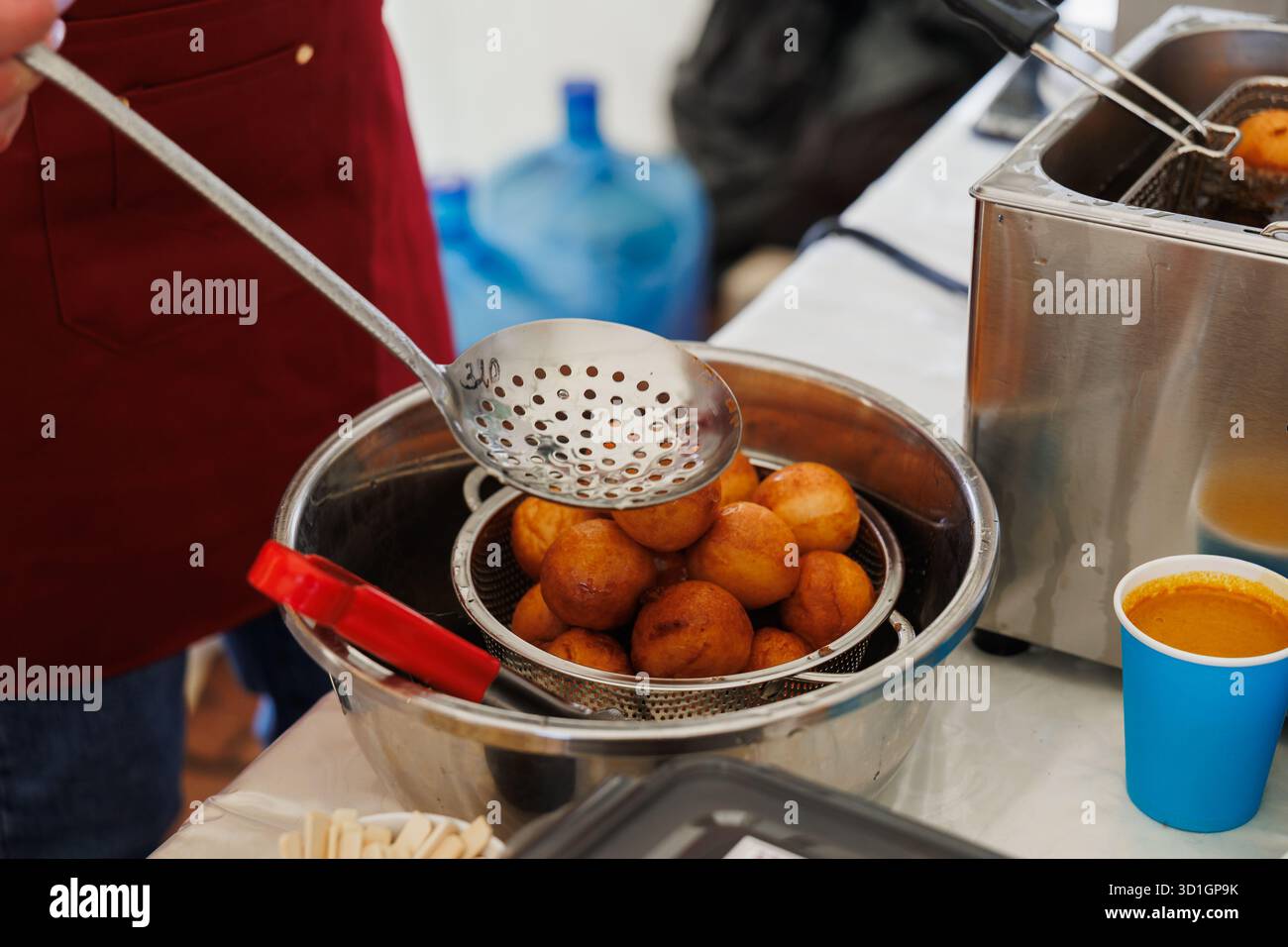 Le palline d'impasto dorate e soffici sono fritte alla perfezione, mostrando arte culinaria e delizioso cibo di strada Foto Stock
