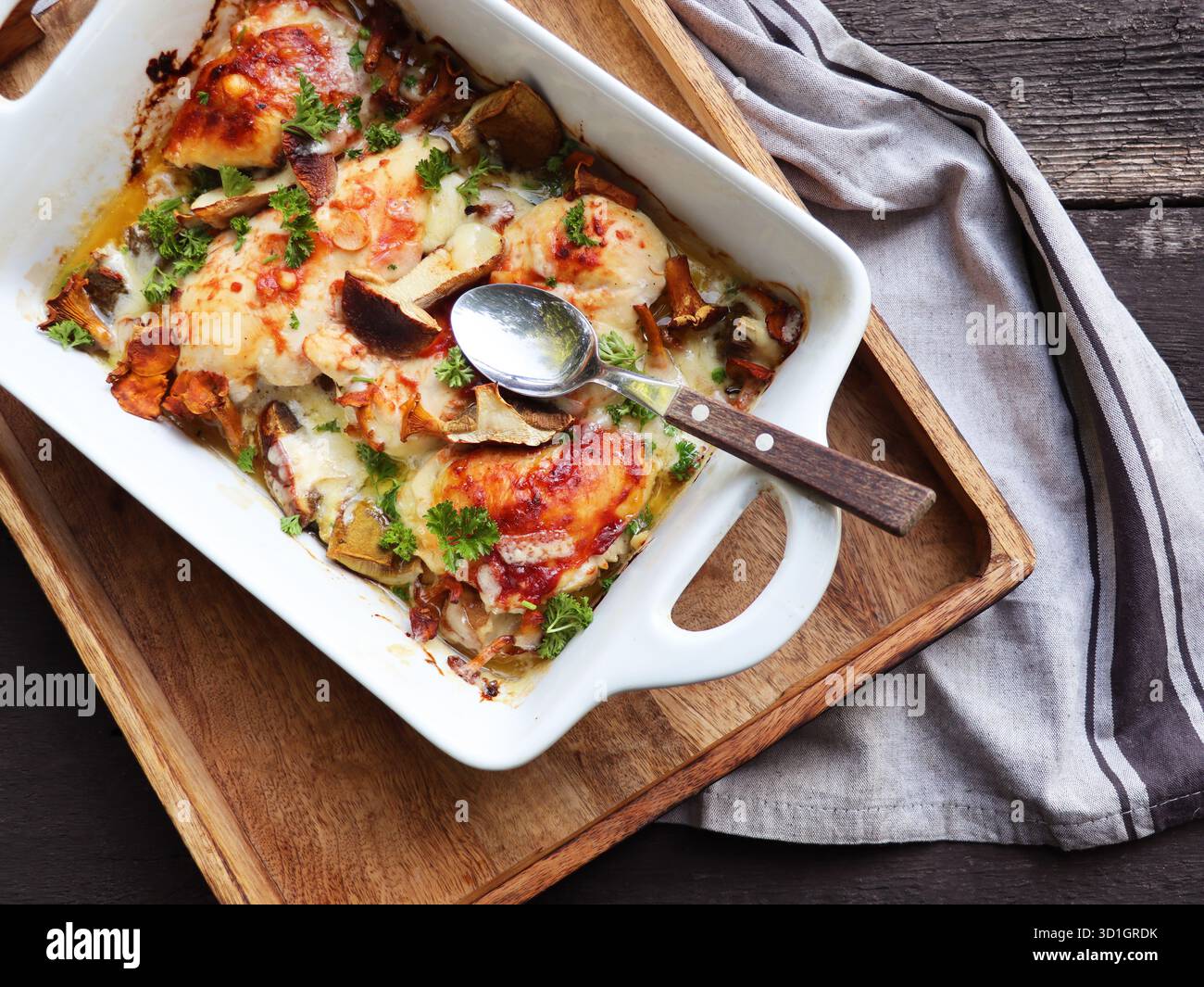 I funghi porcini arrosto, carne di pollo e formaggio gratinato in padella, su sfondo di legno Foto Stock
