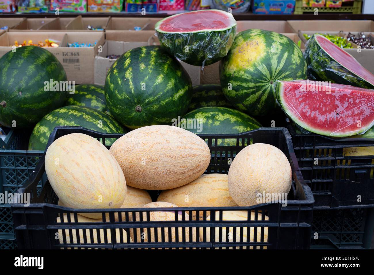 Meloni e angurie nel mercato all'aperto e succosa anguria rossa tagliata a metà. Commercio di strada Foto Stock