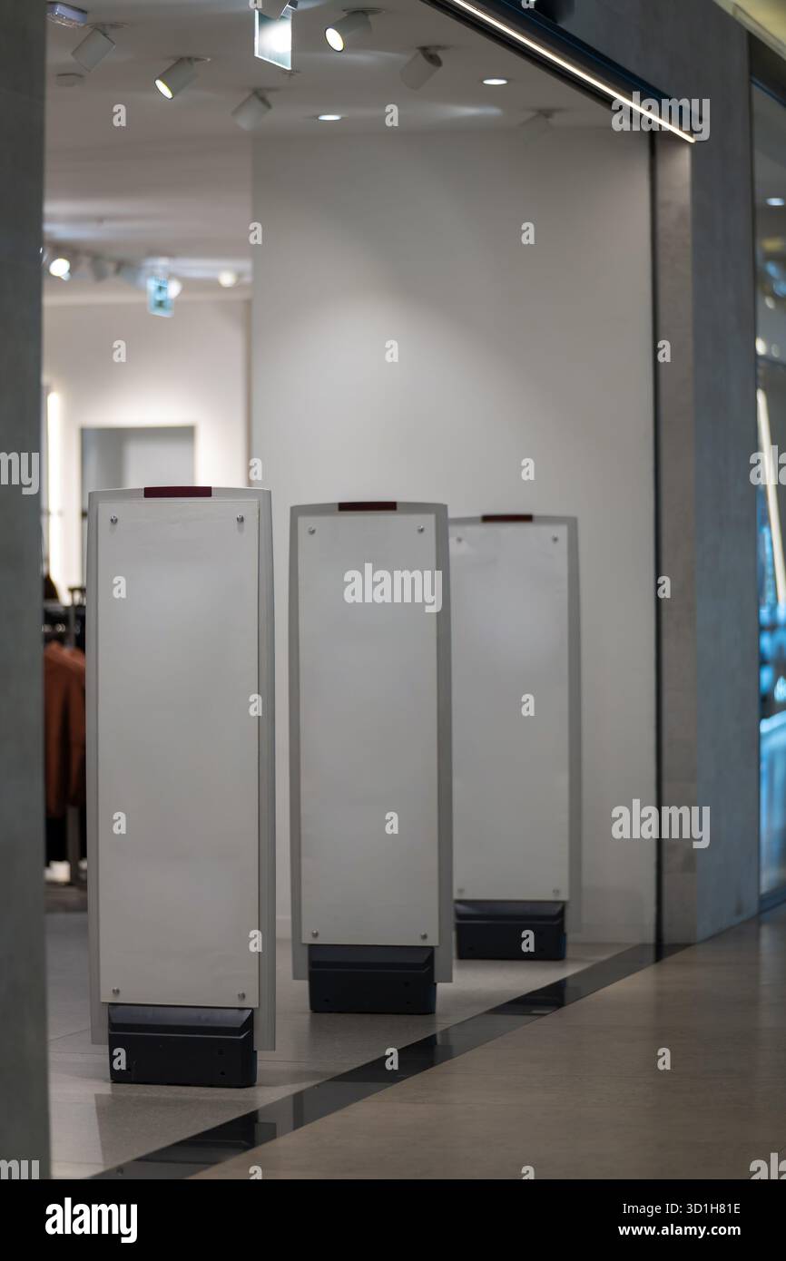 Cancelli di sicurezza a radiofrequenza con rilevatore di metalli integrato all'ingresso di un negozio di abbigliamento, un moderno antifurto e sorveglianza elettronica degli articoli, così via Foto Stock