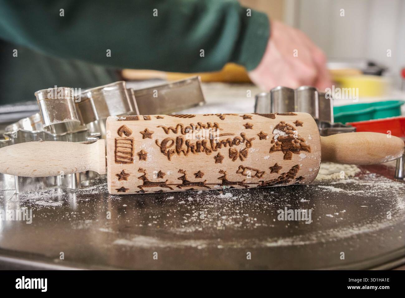 Mattarello impresso con allegro natale, taglierine per biscotti, teglia da forno su un tavolo, primo piano Foto Stock