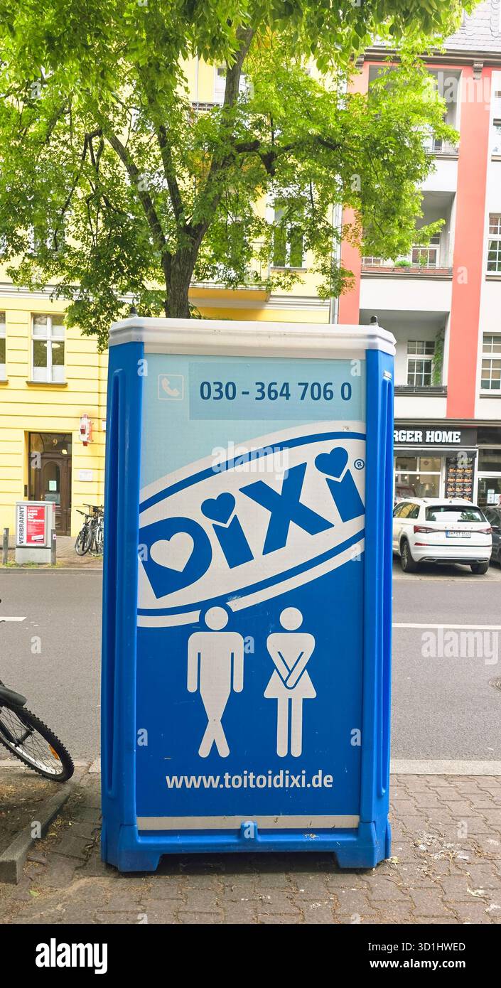 Belin, Germania - 19 maggio 2025: Il bagno portatile DIXI è situato in un'area urbana circondata da alberi ed edifici. - Immagine stock catturata con smartphone