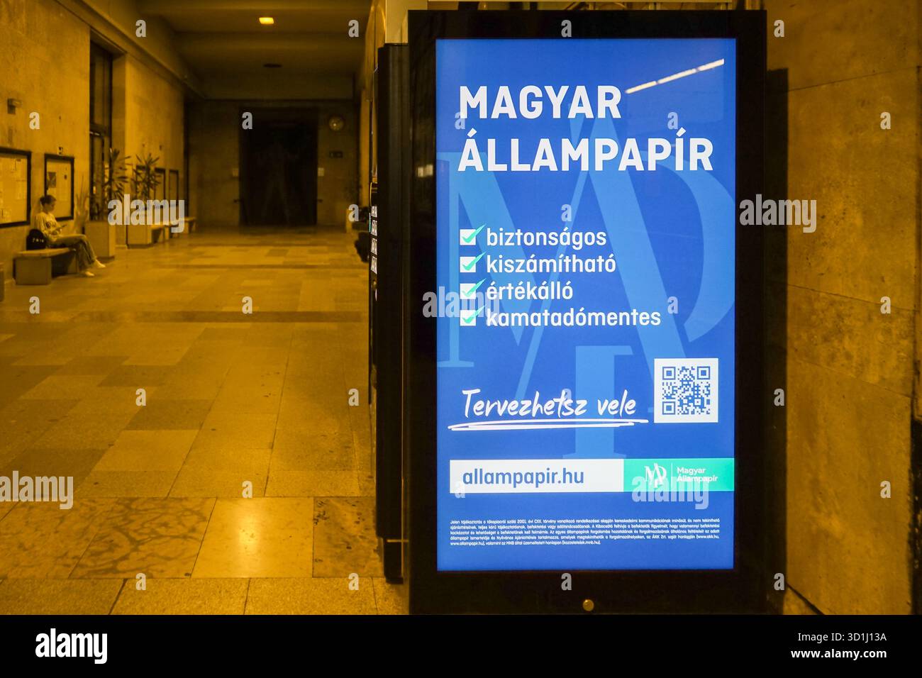 Un'esposizione pubblicitaria alla stazione ferroviaria di Győr promuove il Magyar Állampapír come investimento “sicuro, prevedibile e esente da imposte” con garanzia statale. Foto Stock