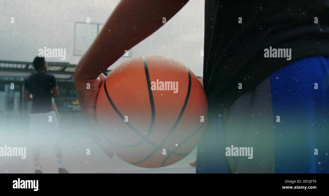 Giocatore di abbigliamento sportivo che tiene il basket sul campo sul tetto, con canestro e tabellone trasparente Foto Stock