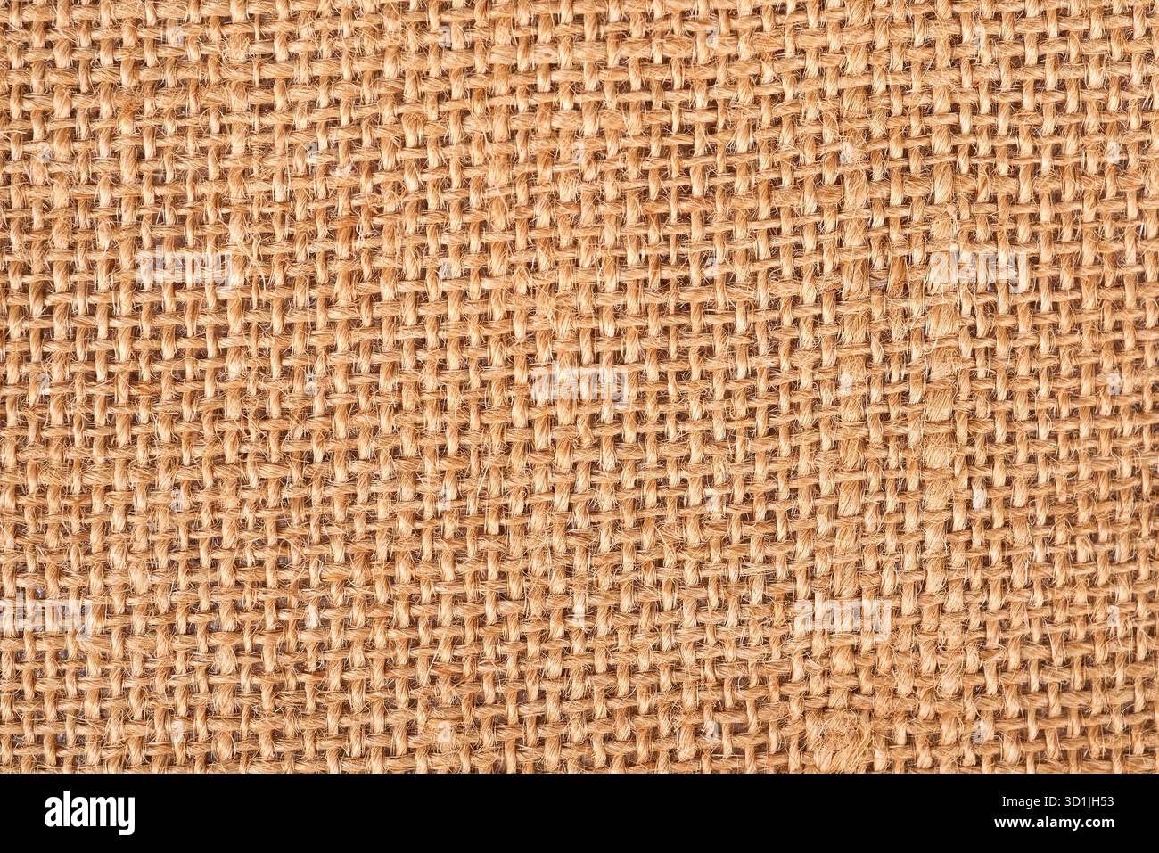 Vista ravvicinata di un tessuto in tela naturale che mostra la sua trama e la sua trama uniche. Questo materiale versatile è ideale per vari tipi di artigianato e per la casa, dicembre Foto Stock