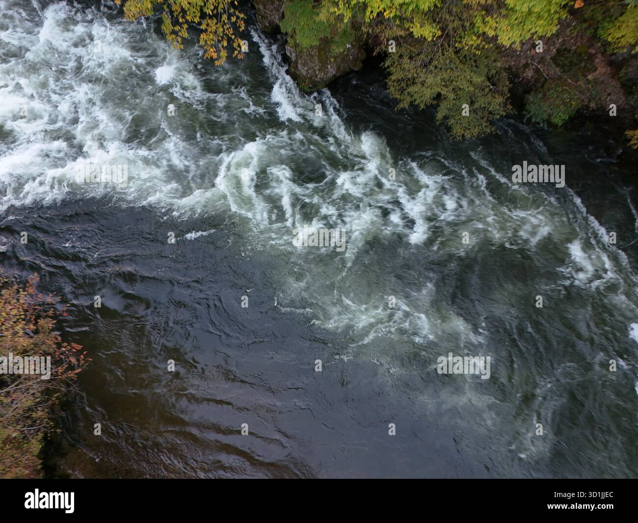 L'acqua scorre rapidamente ed è una tonalità profonda di blu. L'acqua si muove rapidamente ed è molto instabile Foto Stock